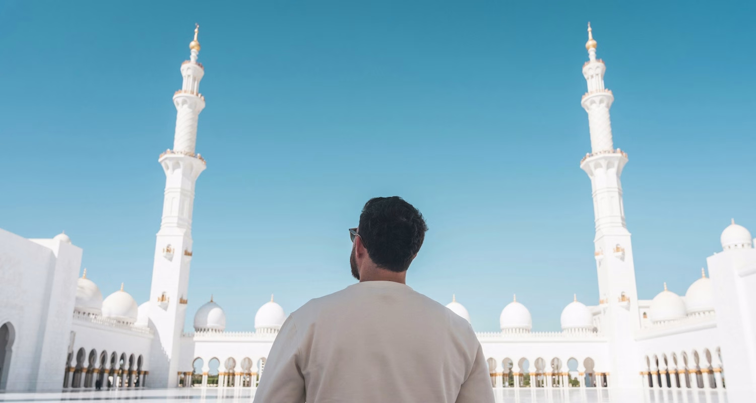 Image of a man stood in front of a mosque in Abu Dhabi