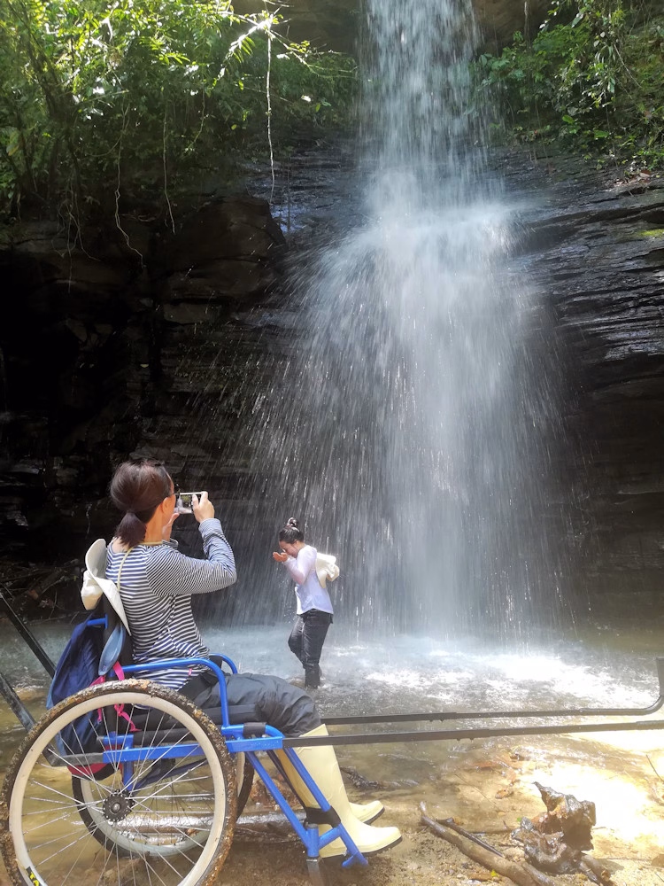 A wheelchair user experiences waterfalls in the Amazon