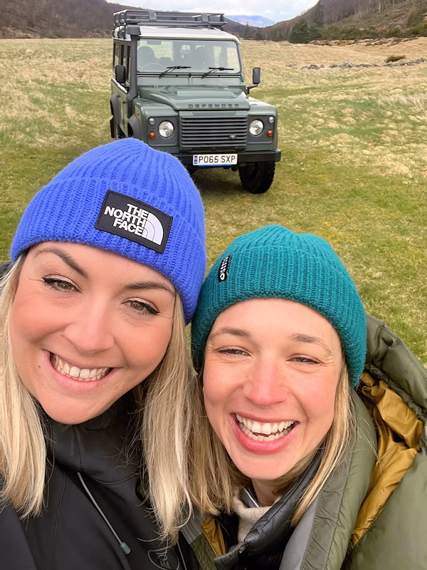 Image of Olivia Cryer and Maudie Tomlinson in the countryside in front of a Land Rover