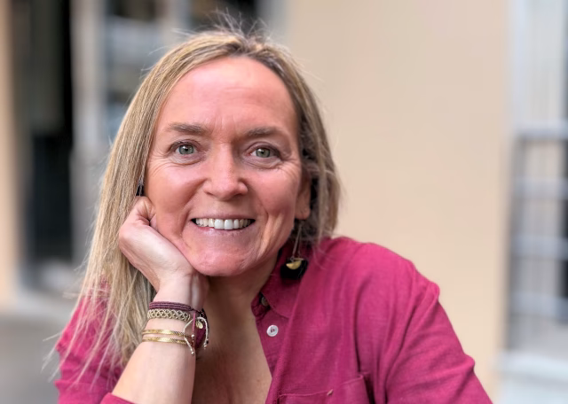 Image of Sofia Martins, resting her head on her hand and smiling