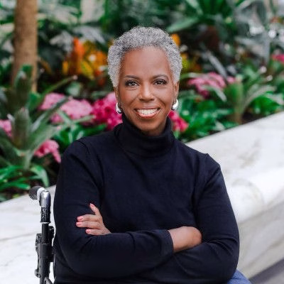 Carmen Daniels Jones has her arms folded and is smiling.