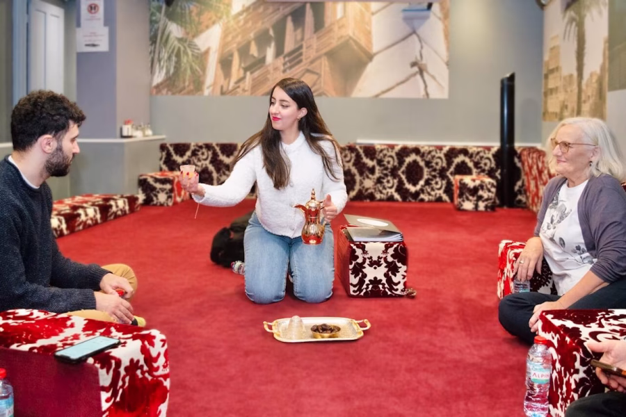 Image shows Amal Ishtar sharing food and drink
