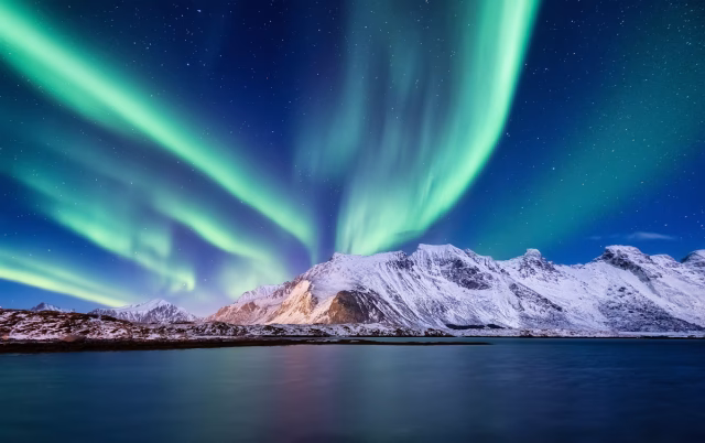 Image shows the Northern Lights (Aurora Borealis) above the Lofoten Islands, Norway